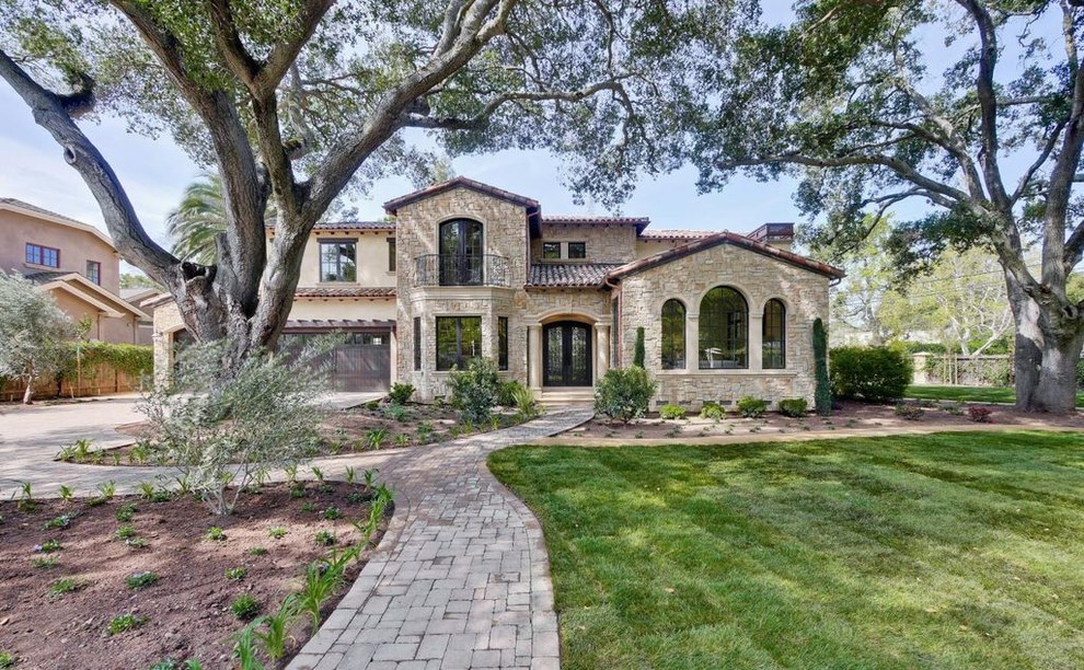 Inspiration for a large mediterranean beige two-story stucco exterior home remodel in San Francisco with a tile roof