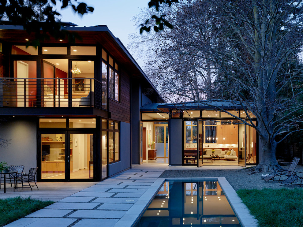 Свежая идея для дизайна: двухэтажный, деревянный частный загородный дом среднего размера в современном стиле с вальмовой крышей и металлической крышей - отличное фото интерьера