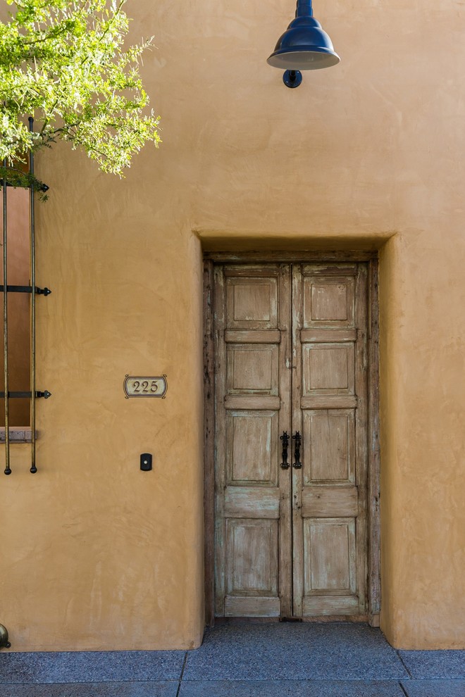 Example of a tuscan yellow two-story stucco exterior home design in Other