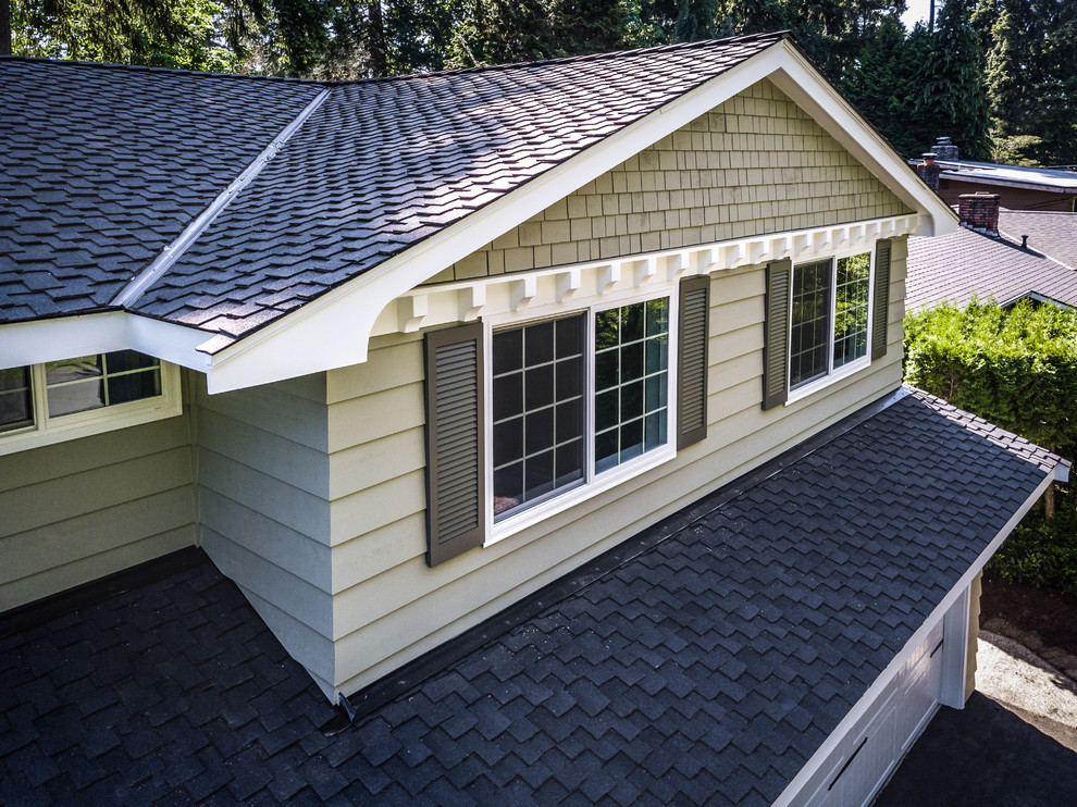 Cette photo montre une façade de maison verte chic en bois de taille moyenne et à un étage avec un toit à deux pans et un toit en shingle.