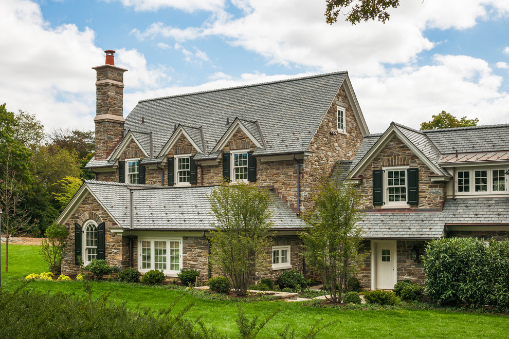 Huge traditional beige two-story stone house exterior idea in Philadelphia