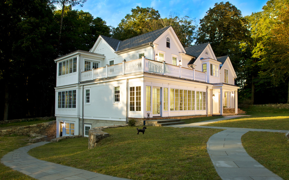Стильный дизайн: белый, большой, деревянный, трехэтажный частный загородный дом в классическом стиле с двускатной крышей - последний тренд