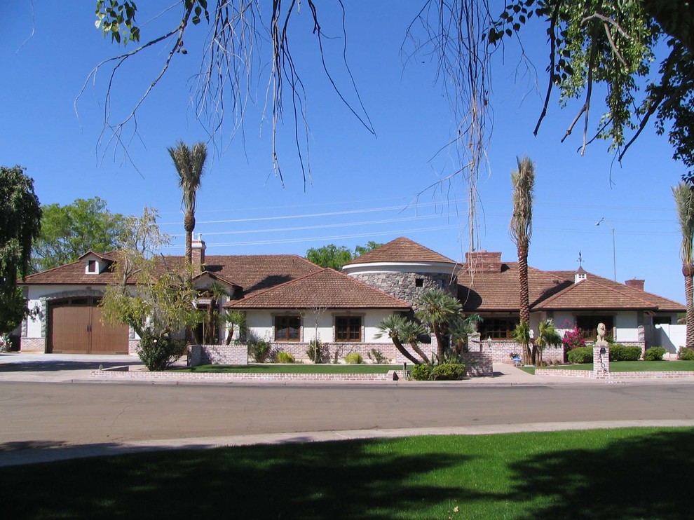Example of a mid-sized classic white one-story stucco exterior home design in Phoenix with a hip roof