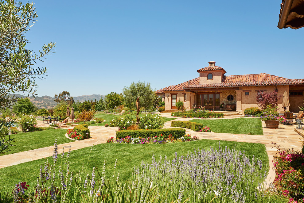 Inspiration for an expansive and beige mediterranean bungalow render house exterior in Santa Barbara.
