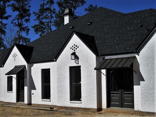 Modern inredning av ett mellanstort grått hus, med allt i ett plan, stuckatur, valmat tak och tak i shingel