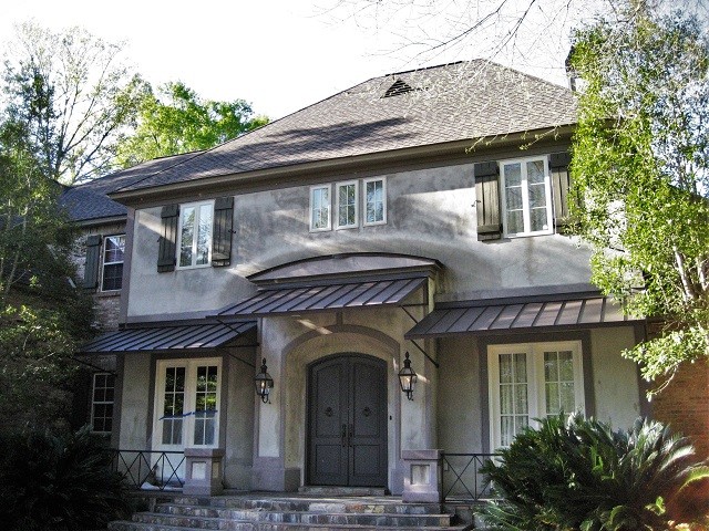 Idée de décoration pour une grande façade de maison grise chalet en béton à un étage avec un toit à quatre pans et un toit en shingle.