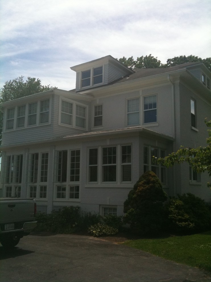 Exemple d'une grande façade de maison blanche chic à un étage avec un revêtement mixte, un toit à quatre pans et un toit mixte.