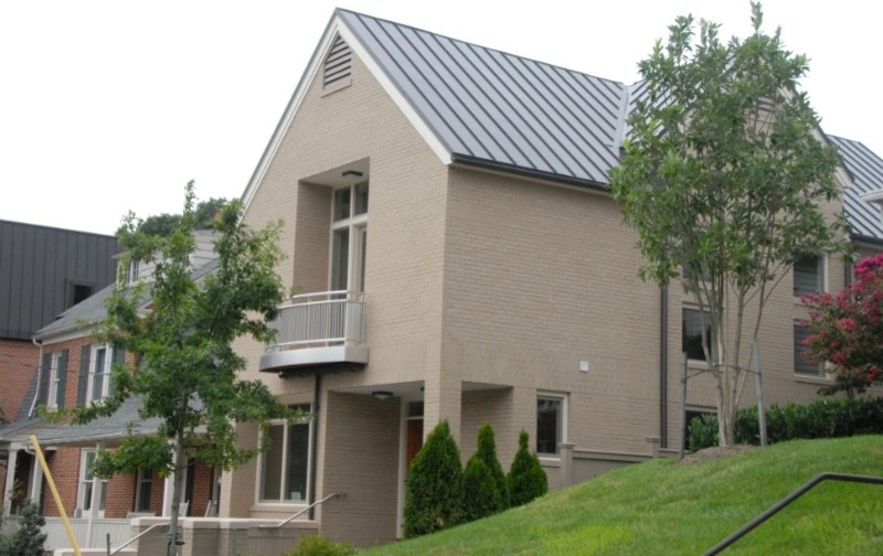 На фото: большой, двухэтажный, кирпичный, бежевый частный загородный дом в классическом стиле с двускатной крышей и металлической крышей