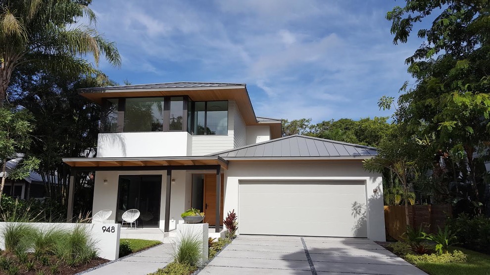 Inspiration for a large timeless white two-story concrete house exterior remodel in Tampa with a metal roof