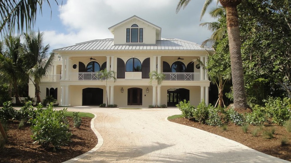 Ejemplo de fachada de casa beige mediterránea grande de dos plantas con revestimiento de hormigón, tejado plano y tejado de metal