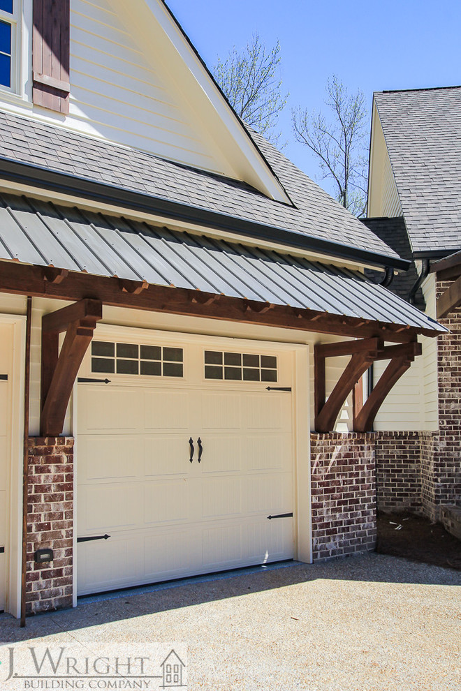 Metal shed roof over garage doors with wood brackets Traditional