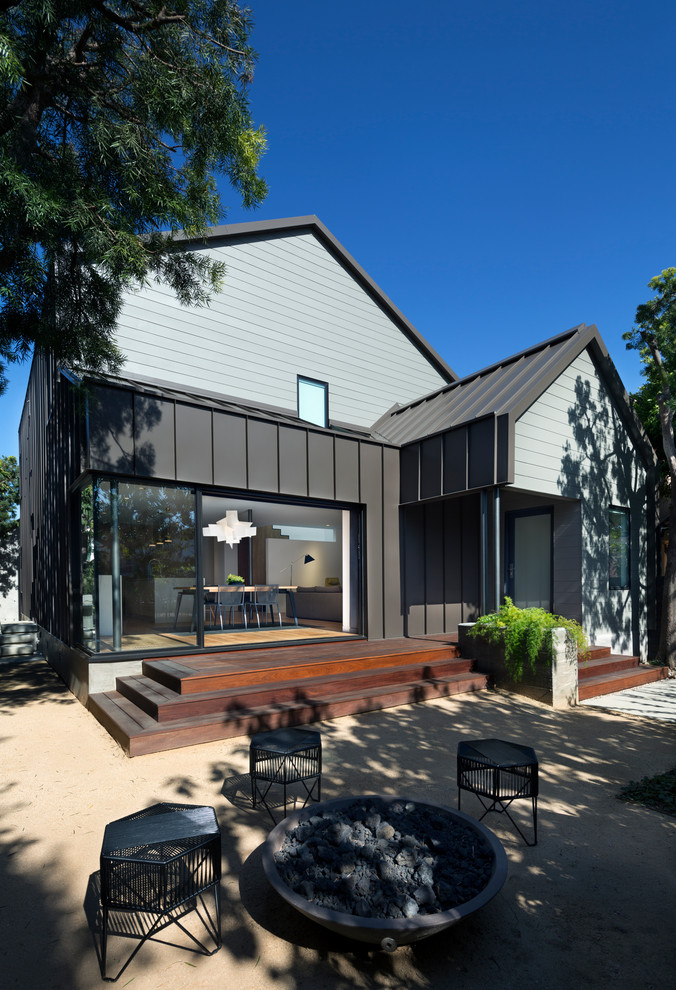 Immagine della facciata di una casa contemporanea a due piani di medie dimensioni con rivestimento in metallo e copertura in metallo o lamiera