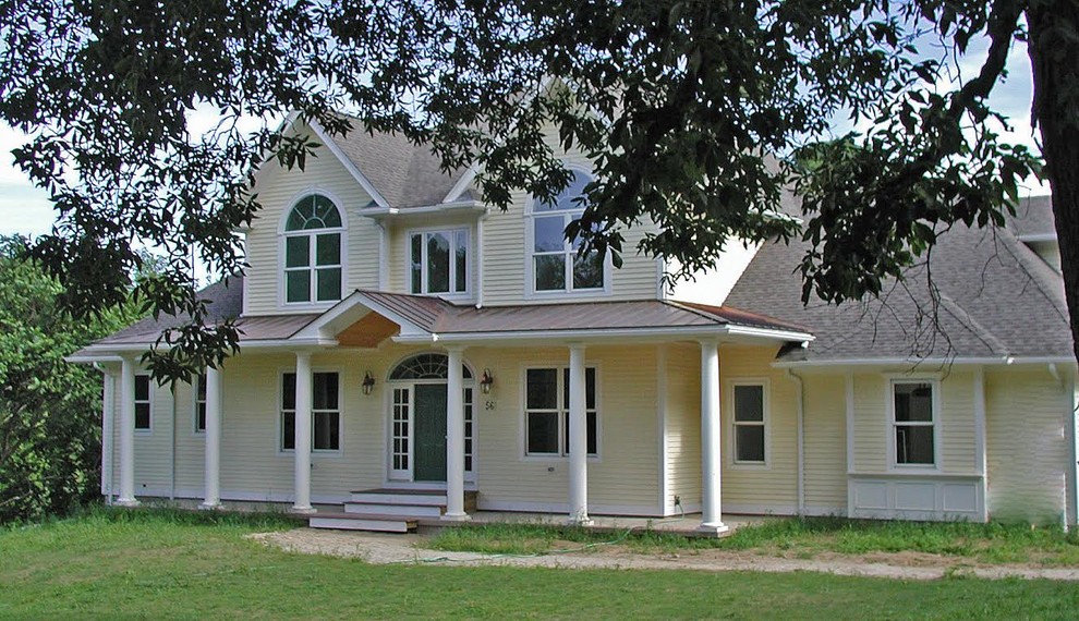 Exemple d'une grande façade de maison grise bord de mer en stuc à un étage avec un toit à quatre pans.