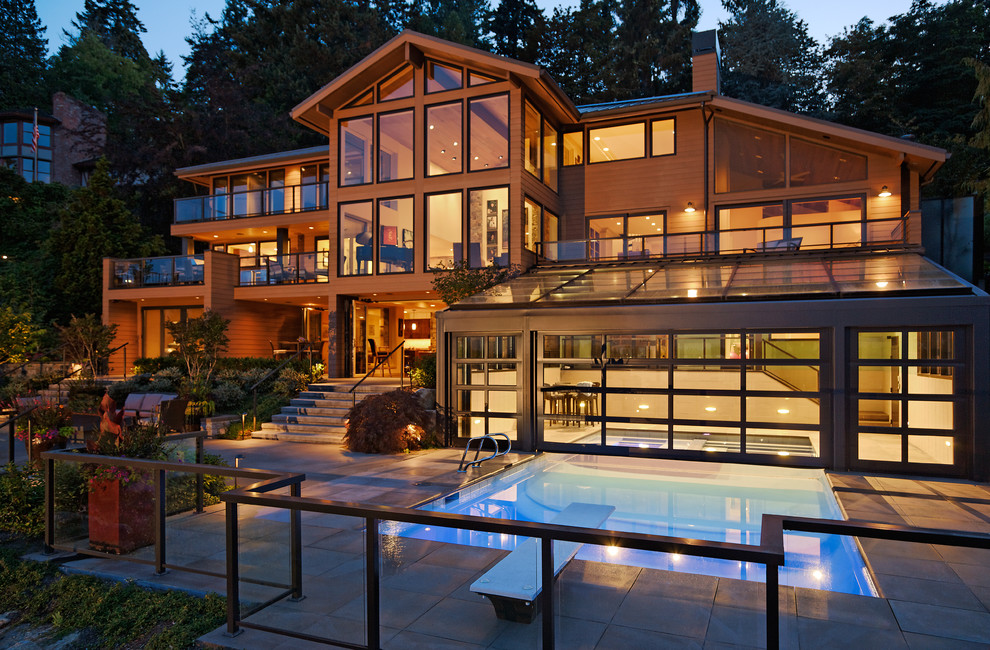 Cette photo montre une très grande façade de maison marron tendance en bois à deux étages et plus avec un toit à deux pans.
