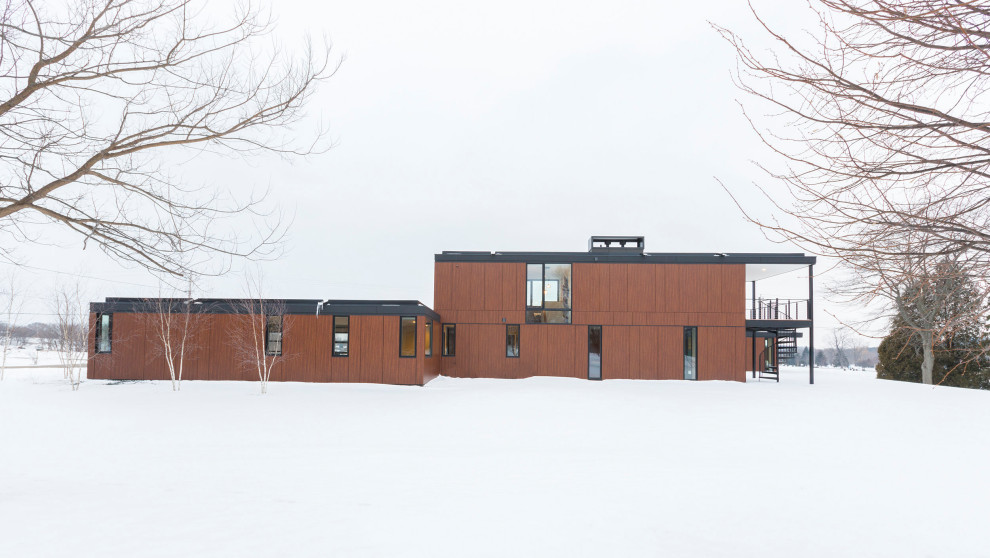 Inspiration for a large and brown modern two floor detached house in Milwaukee with wood cladding and a flat roof.