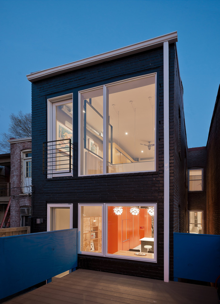 Cette image montre une façade de maison marron minimaliste en brique de taille moyenne et à un étage avec un toit plat.