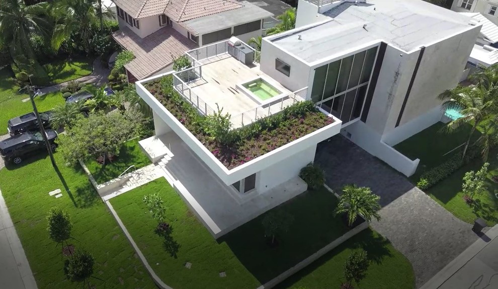 Foto de fachada de casa blanca moderna de tamaño medio de dos plantas con revestimiento de hormigón, tejado plano y tejado de varios materiales