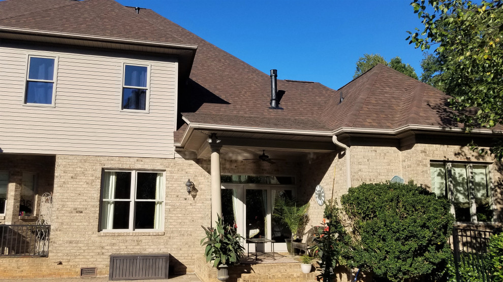 This is an example of a large and brown classic two floor brick detached house in Charlotte with a hip roof and a shingle roof.