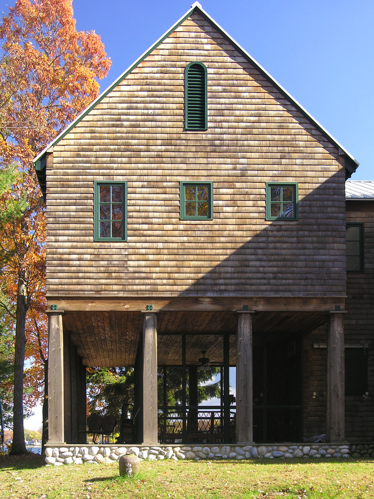 This is an example of a rustic house exterior in Chicago with wood cladding and a pitched roof.