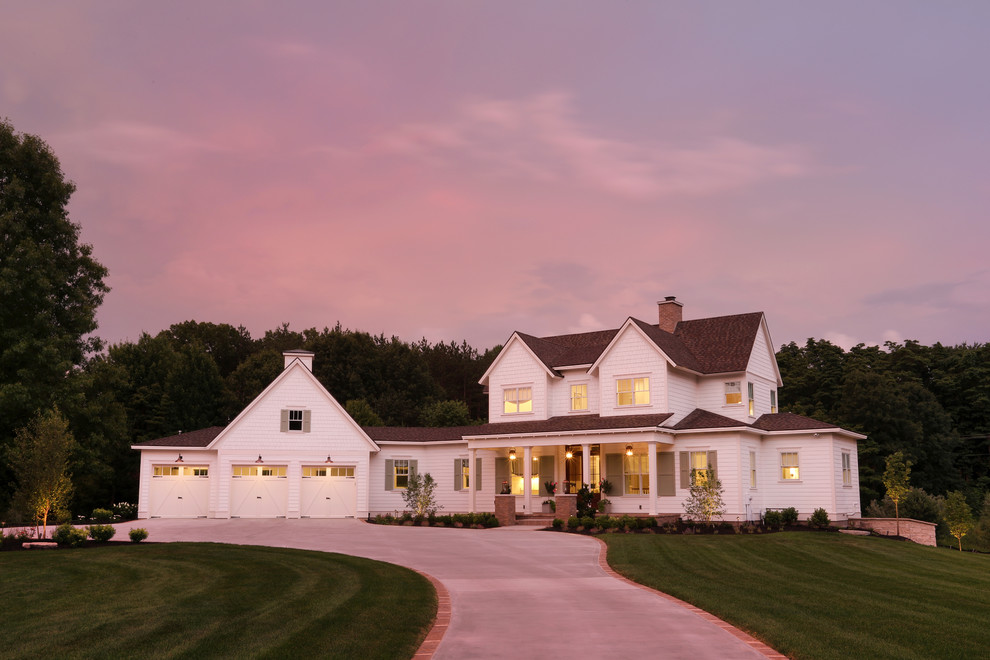 Foto della villa grande bianca country a due piani con rivestimento con lastre in cemento, tetto a capanna e copertura a scandole