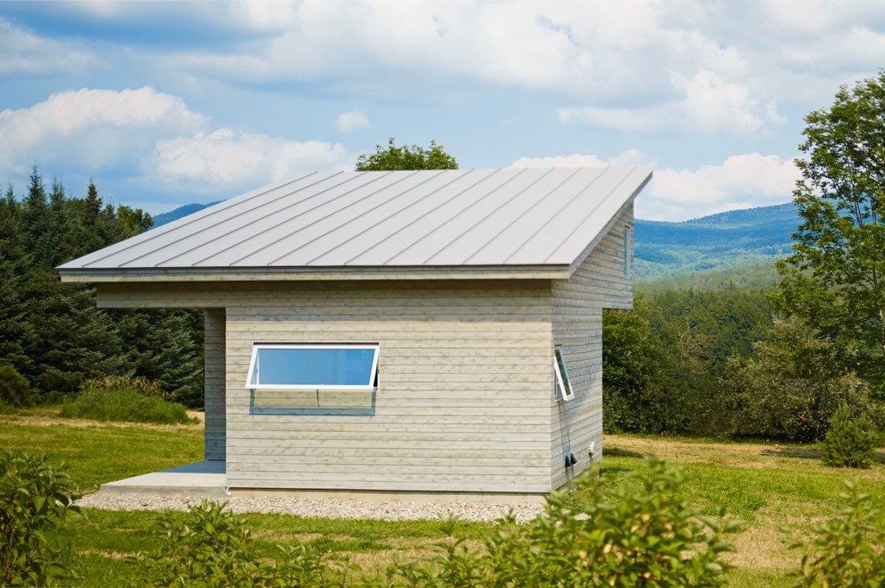 This is an example of a small and gey modern bungalow house exterior in Burlington with wood cladding and a lean-to roof.