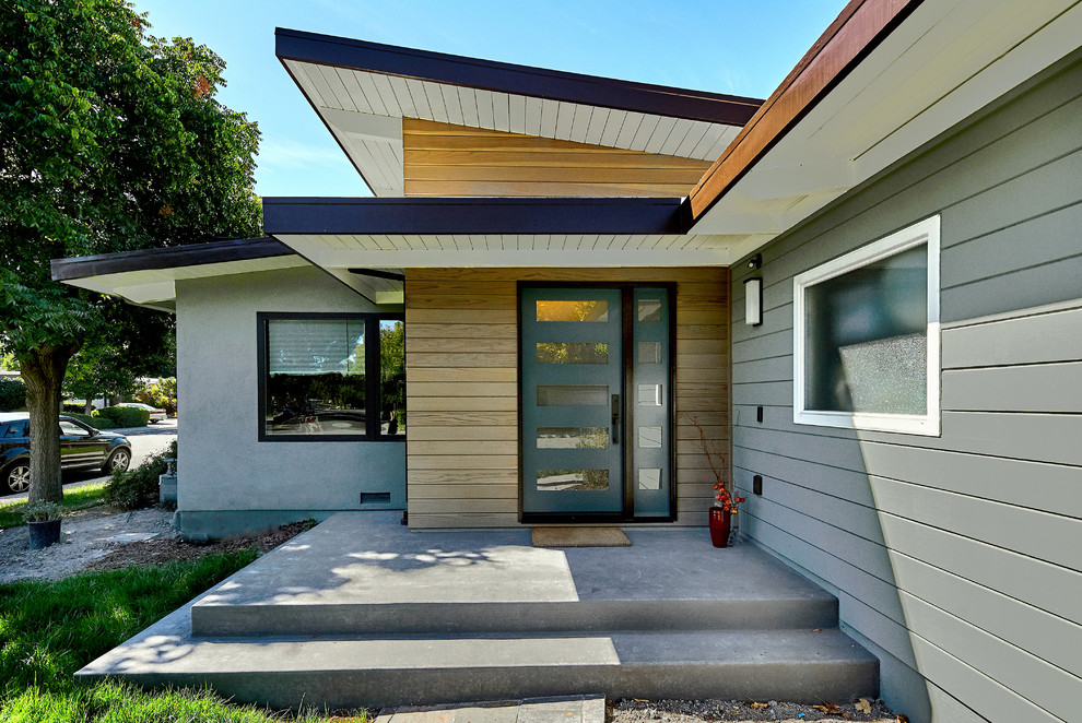 Modelo de fachada de casa gris retro de tamaño medio de una planta con revestimientos combinados y tejado plano