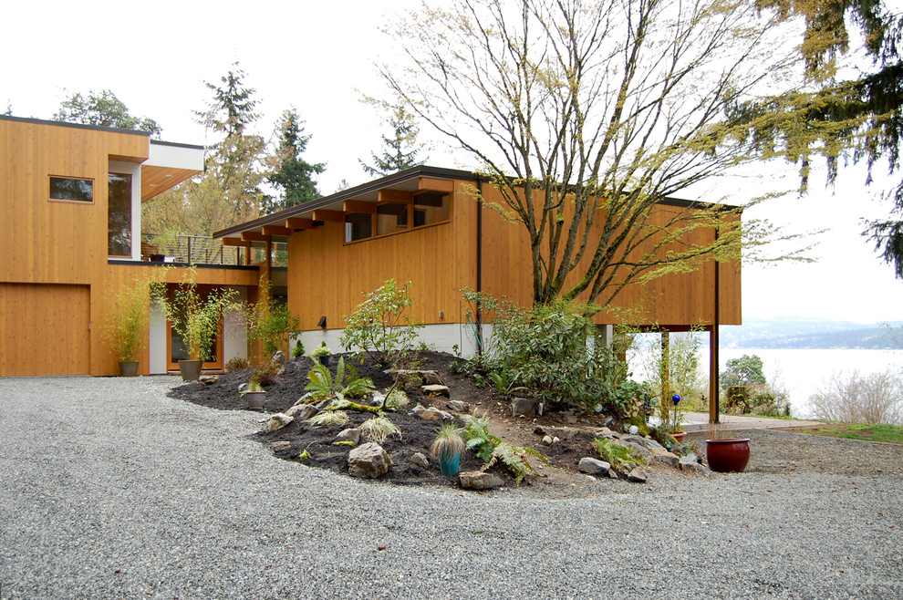 Design ideas for a modern two floor house exterior in Seattle with wood cladding and a flat roof.
