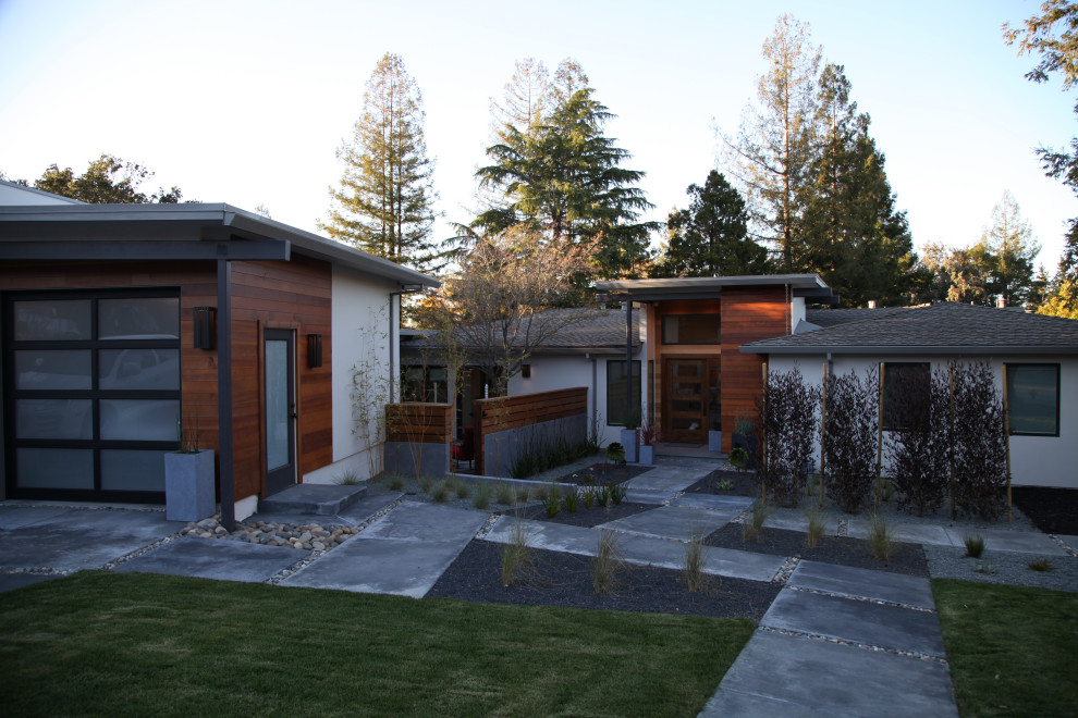 Photo of a large and beige midcentury bungalow render and front detached house in San Francisco with a flat roof, a mixed material roof and a brown roof.