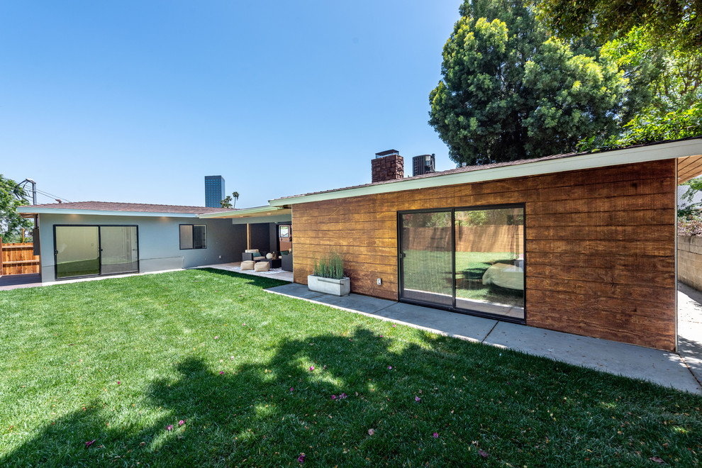 Cette image montre une grande façade de maison grise design en bois de plain-pied avec un toit à deux pans et un toit en shingle.