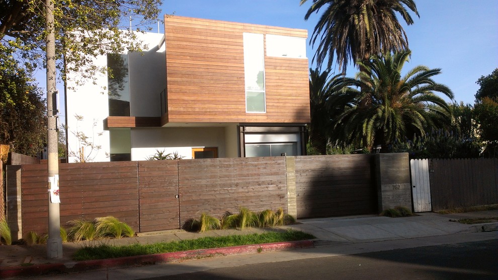 На фото: двухэтажный, бежевый дом среднего размера в стиле ретро с облицовкой из цементной штукатурки и полувальмовой крышей с