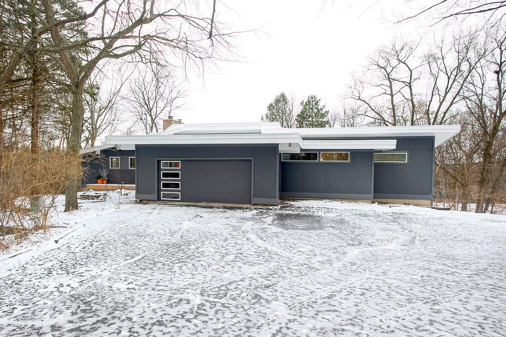 Aménagement d'une façade de maison grise rétro de taille moyenne et de plain-pied avec un revêtement en vinyle et un toit de Gambrel.