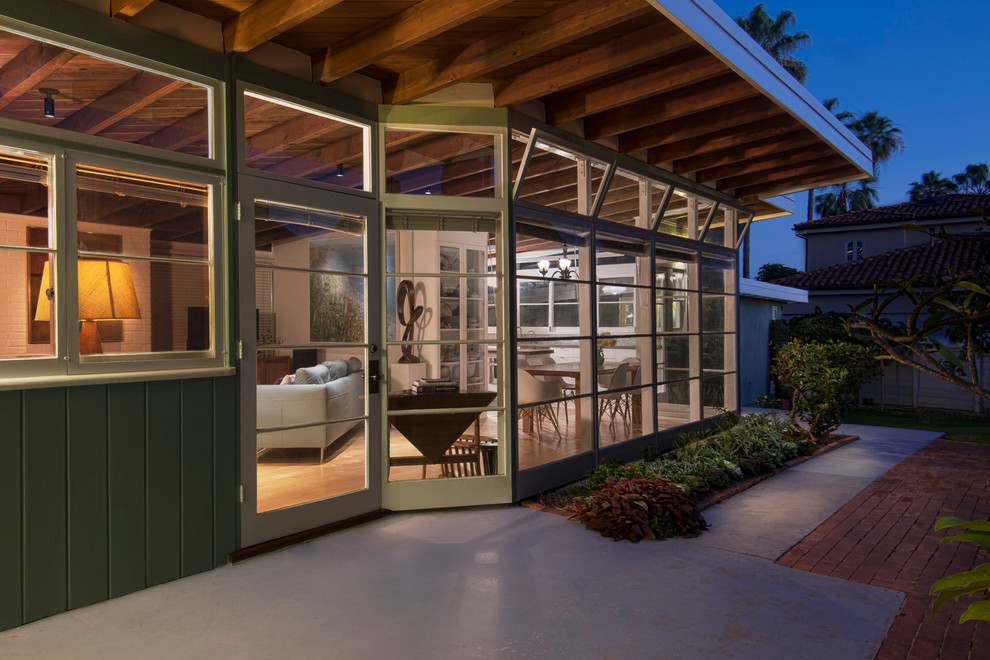 Photo of a green midcentury bungalow house exterior in San Diego with wood cladding.