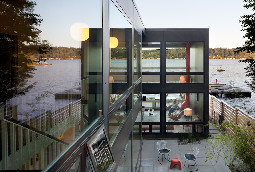 Zweistöckiges Mid-Century Einfamilienhaus mit Metallfassade, schwarzer Fassadenfarbe und Flachdach in Seattle