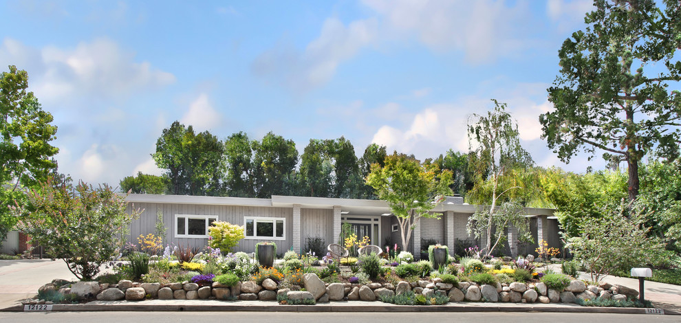 Inspiration for a mid-sized 1960s gray one-story mixed siding flat roof remodel in Orange County