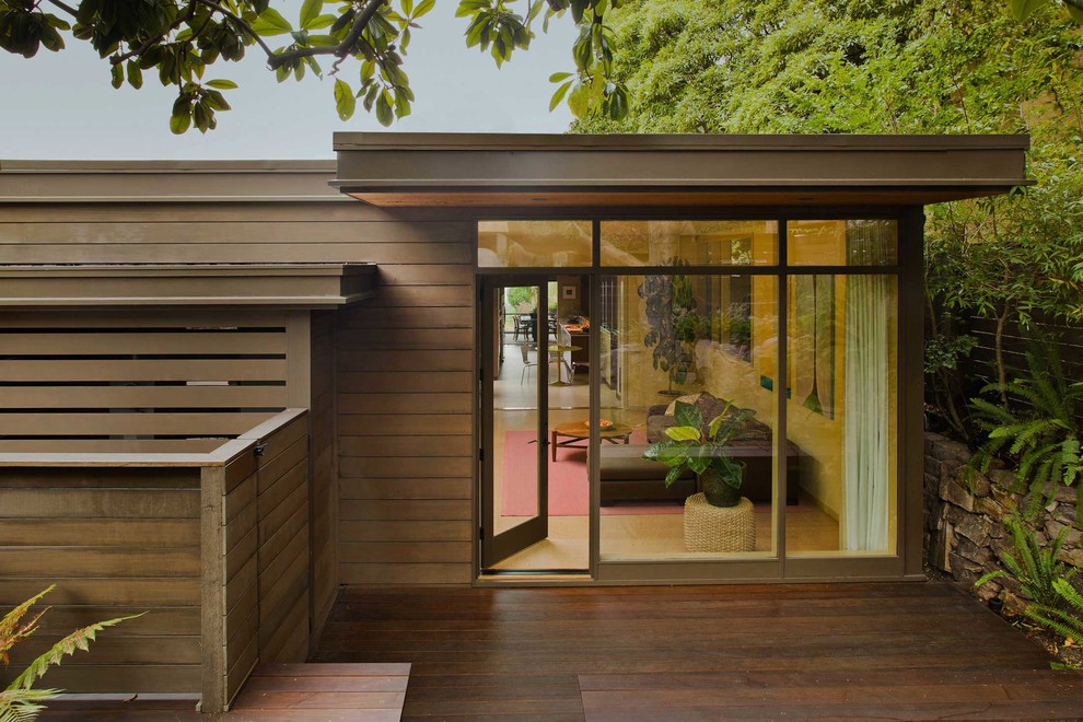 Diseño de fachada marrón moderna grande de dos plantas con revestimiento de madera y tejado plano