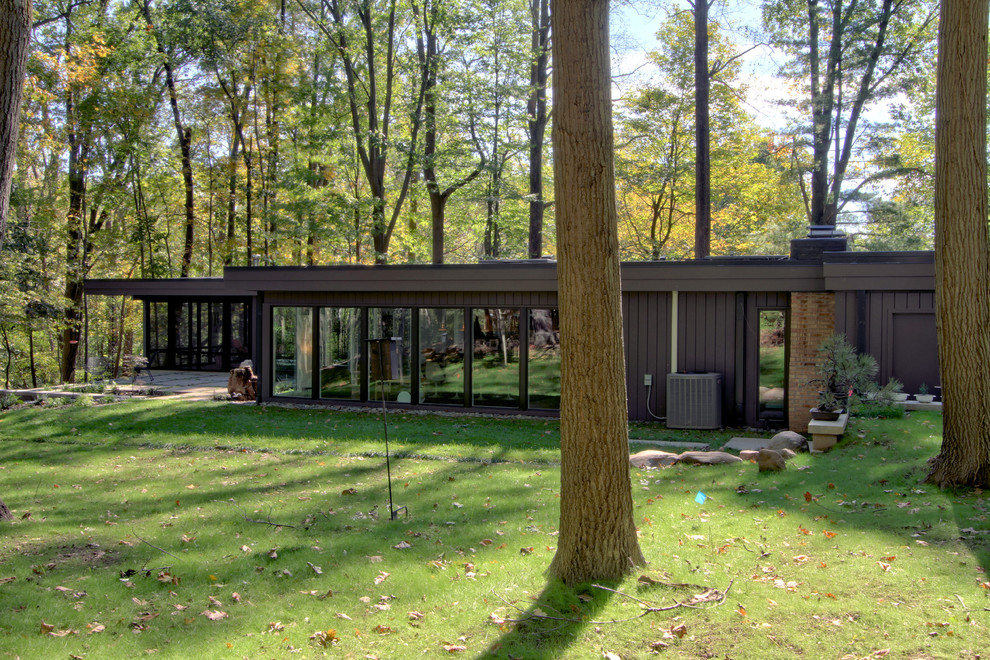 Inspiration pour une façade de maison marron vintage en bois de taille moyenne et de plain-pied avec un toit plat et un toit mixte.