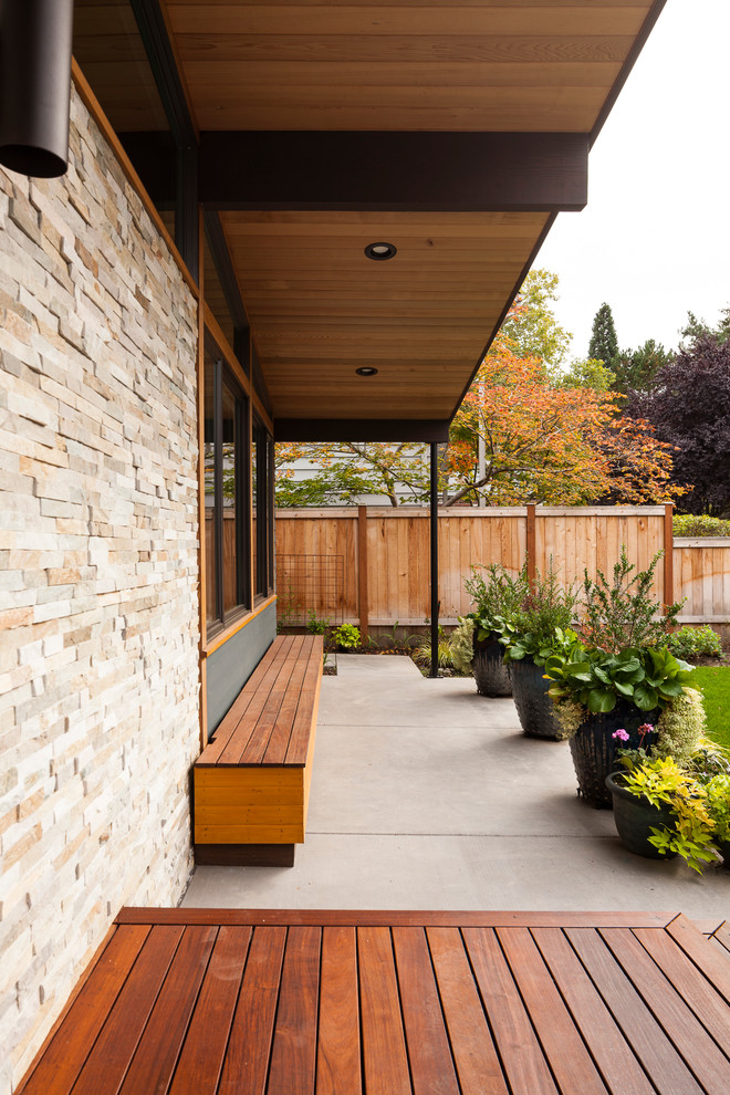Medium sized and blue midcentury bungalow house exterior in Seattle with concrete fibreboard cladding.