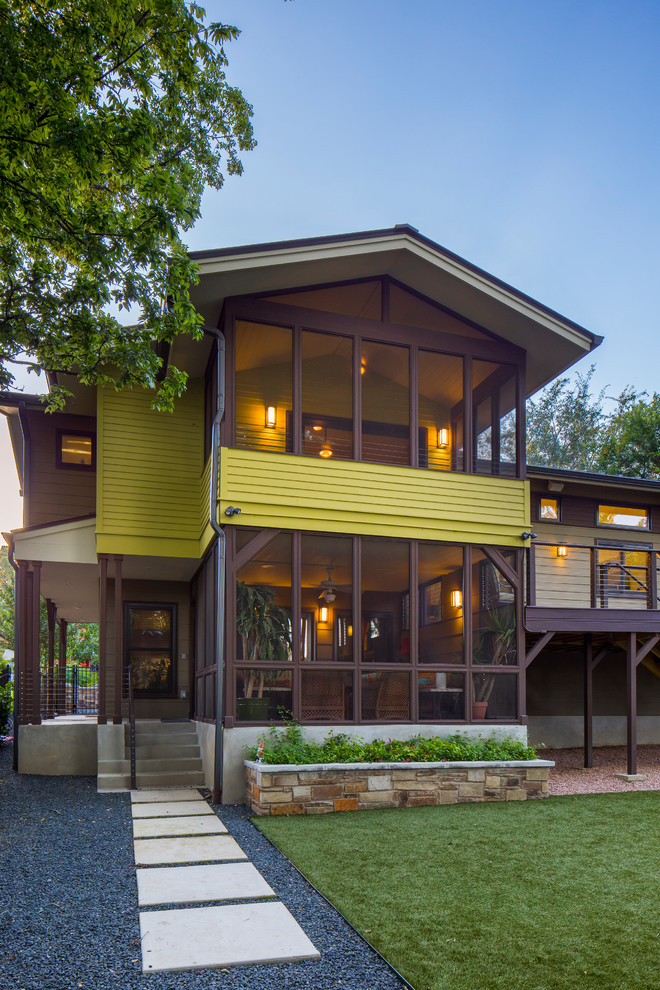 Пример оригинального дизайна: большой, двухэтажный, желтый частный загородный дом в классическом стиле с облицовкой из ЦСП, двускатной крышей и металлической крышей