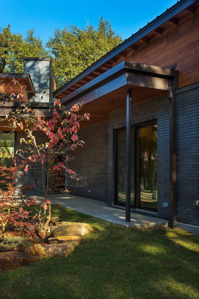Diseño de fachada de casa gris retro de tamaño medio de dos plantas con revestimientos combinados y tejado de metal