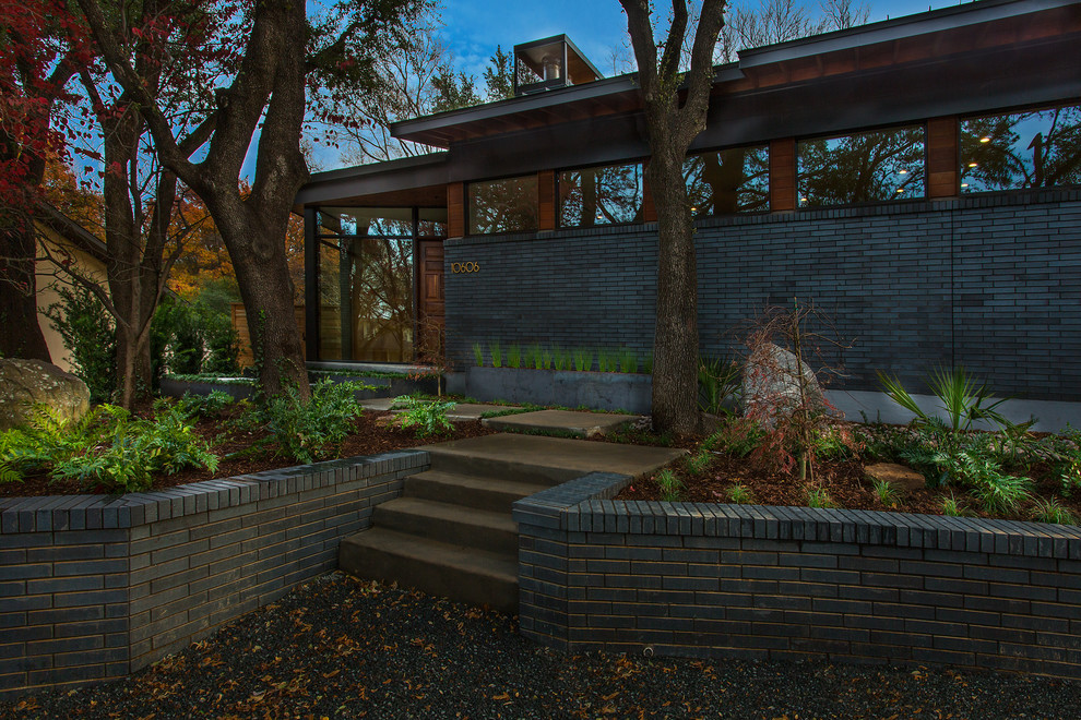 Foto de fachada de casa gris retro de tamaño medio de dos plantas con revestimientos combinados y tejado de metal