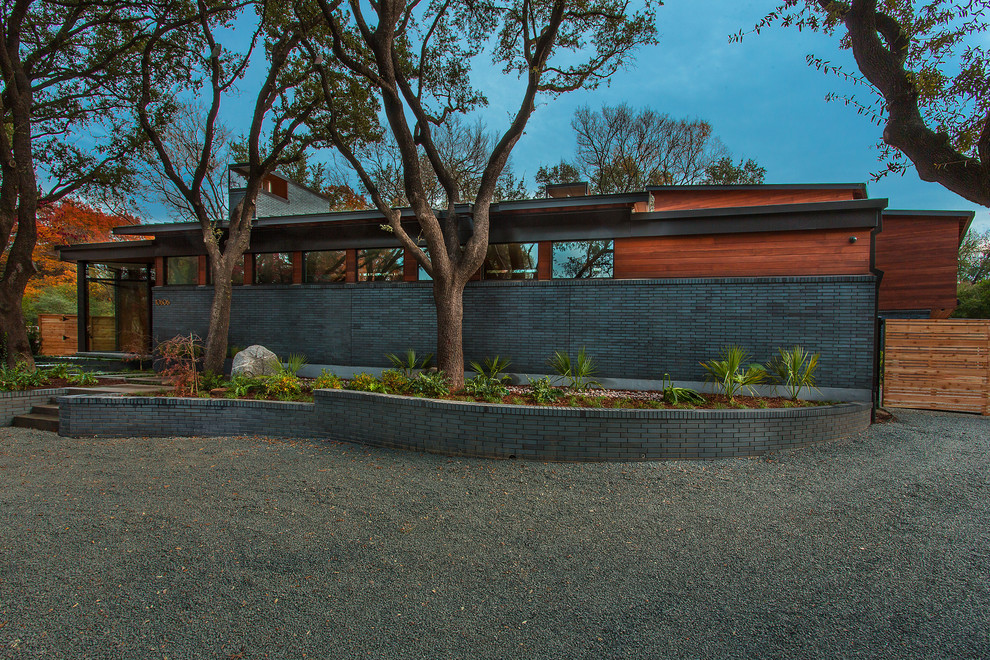 Mittelgroßes, Zweistöckiges Retro Einfamilienhaus mit Mix-Fassade, grauer Fassadenfarbe und Blechdach in Dallas