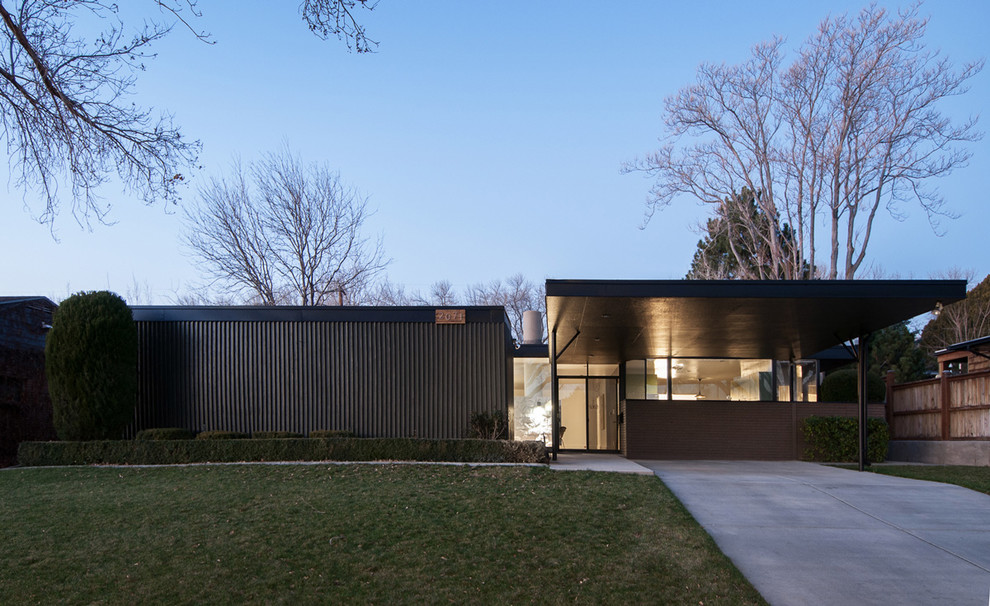 На фото: дом в стиле ретро с облицовкой из металла и плоской крышей