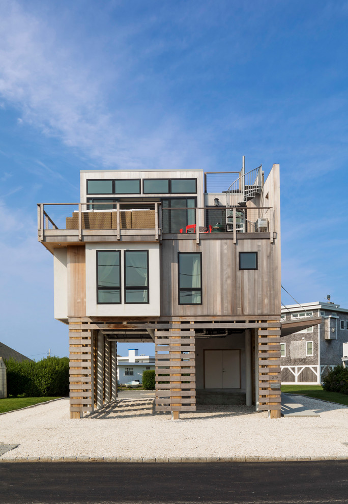 На фото: большой, трехэтажный, разноцветный частный загородный дом в морском стиле с комбинированной облицовкой с