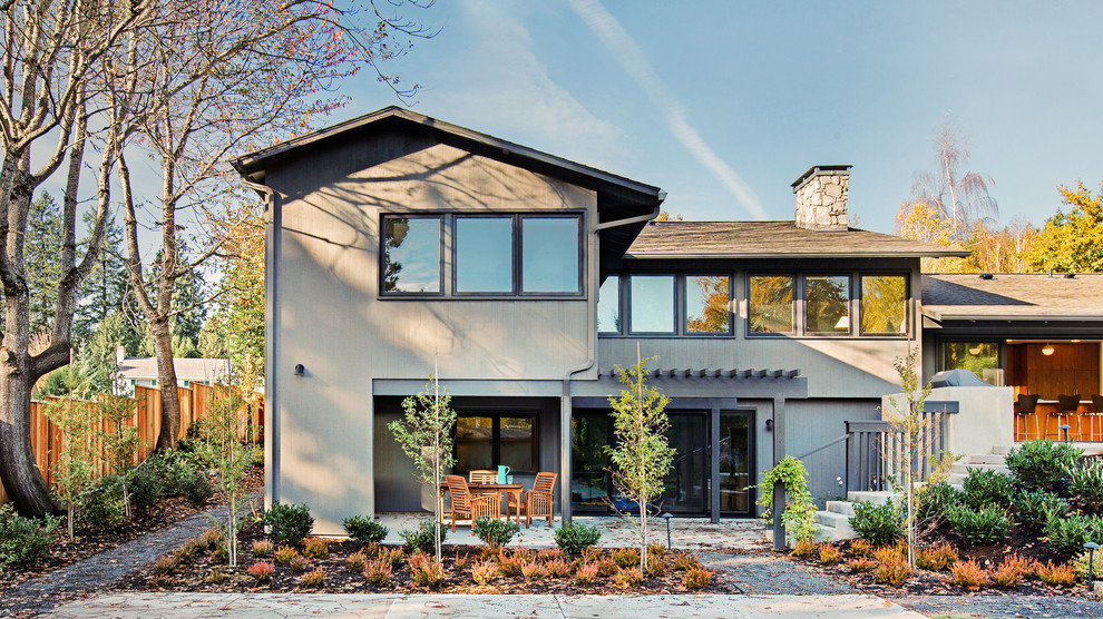 На фото: деревянный, серый дом в современном стиле с разными уровнями и двускатной крышей