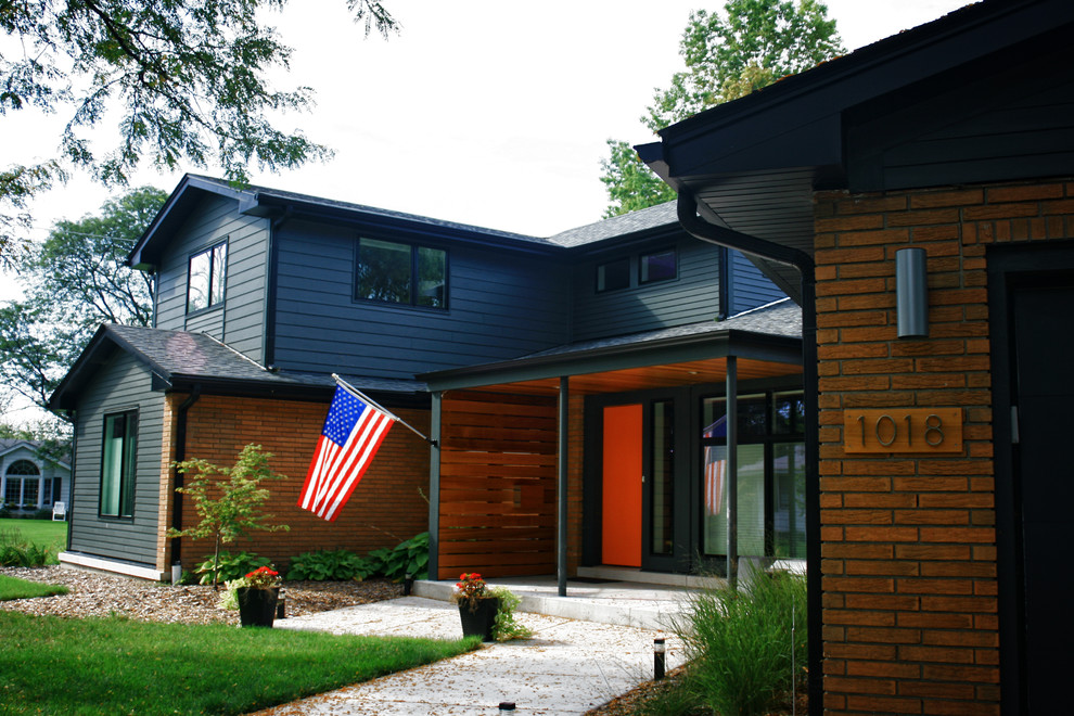 Diseño de fachada azul retro de tamaño medio de dos plantas con revestimientos combinados y tejado a dos aguas