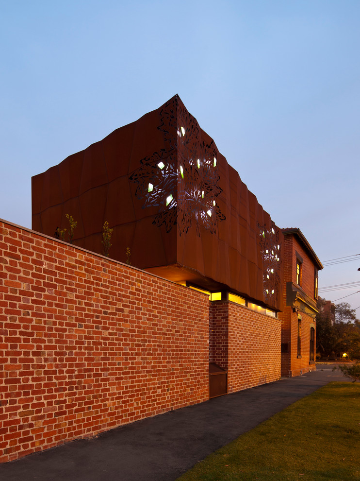 Immagine della facciata di una casa grande marrone contemporanea a due piani con rivestimento in metallo e tetto piano