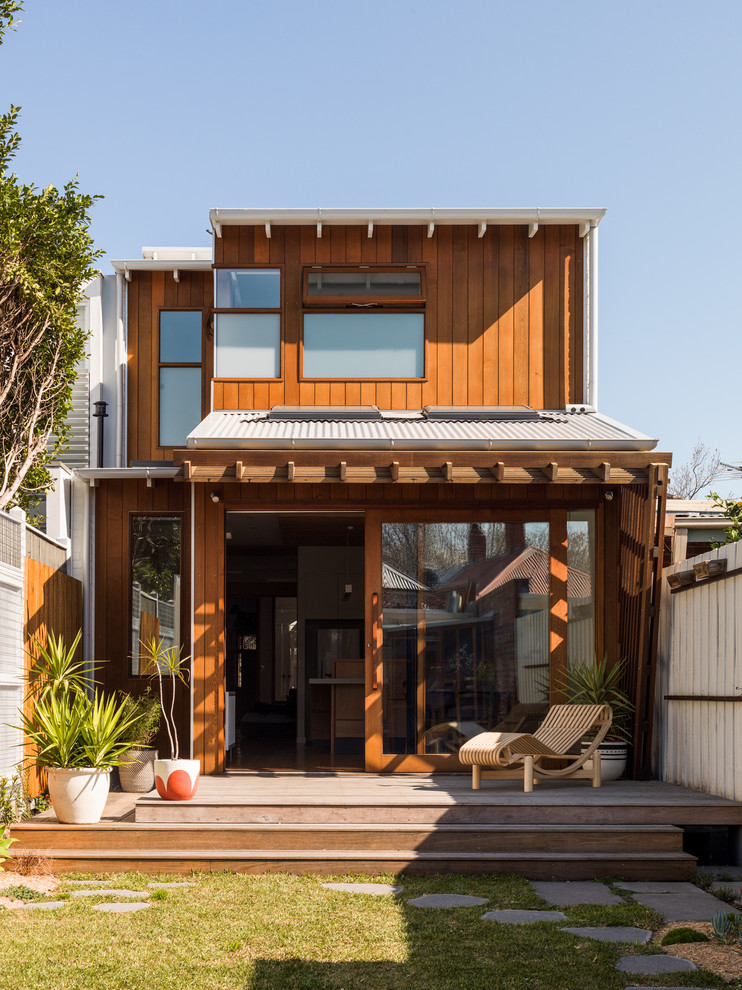 На фото: двухэтажный, деревянный, коричневый дом из контейнеров, из контейнеров в современном стиле с односкатной крышей и металлической крышей с