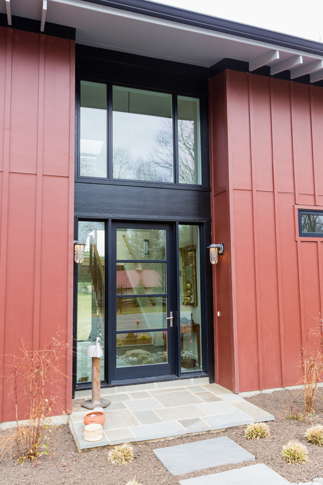 Aménagement d'une grande façade de maison rouge campagne à un étage avec un toit en appentis.