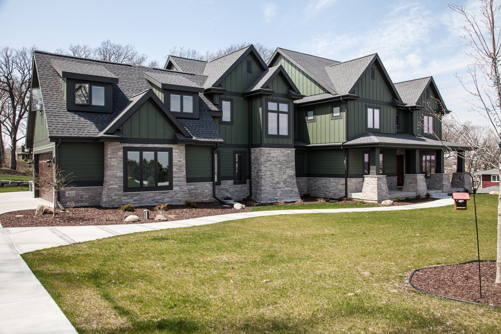 Imagen de fachada de casa verde de estilo americano de dos plantas con revestimientos combinados
