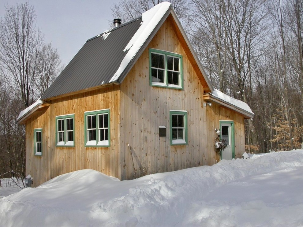 Design ideas for a small rustic two floor house exterior in Burlington with wood cladding.